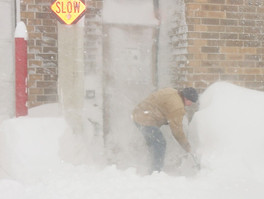Man shoveling snow in blizzard