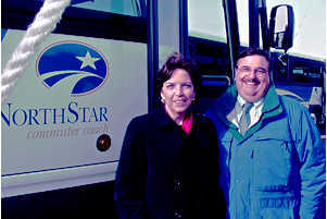 Woman, man alongside NorthStar Commuter Coach bus