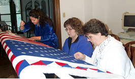 3 women quilting American flag