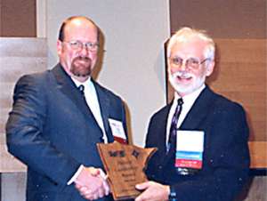 2 men holding award