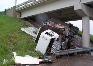 Truck crumpled beneath bridge
