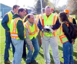 Group in safety vests looking at GPS receiver