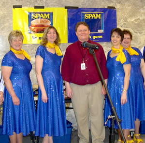 Man standing next to 4 women in blue dresses