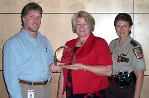 3 people holding award 
