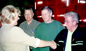 Woman shaking hands with 3 men