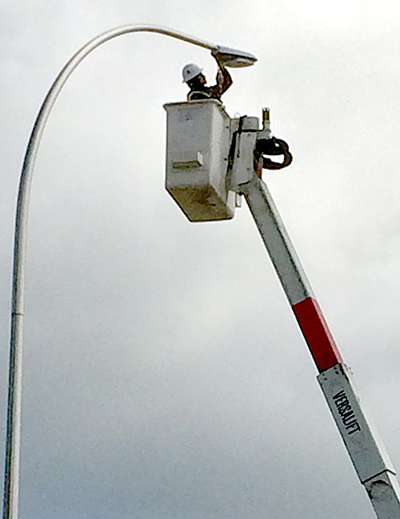 Photo of a crew member replacing a light fixture on Hwy 52.