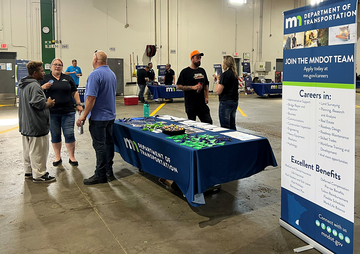 MnDOT staff speak with public around tables in truck station