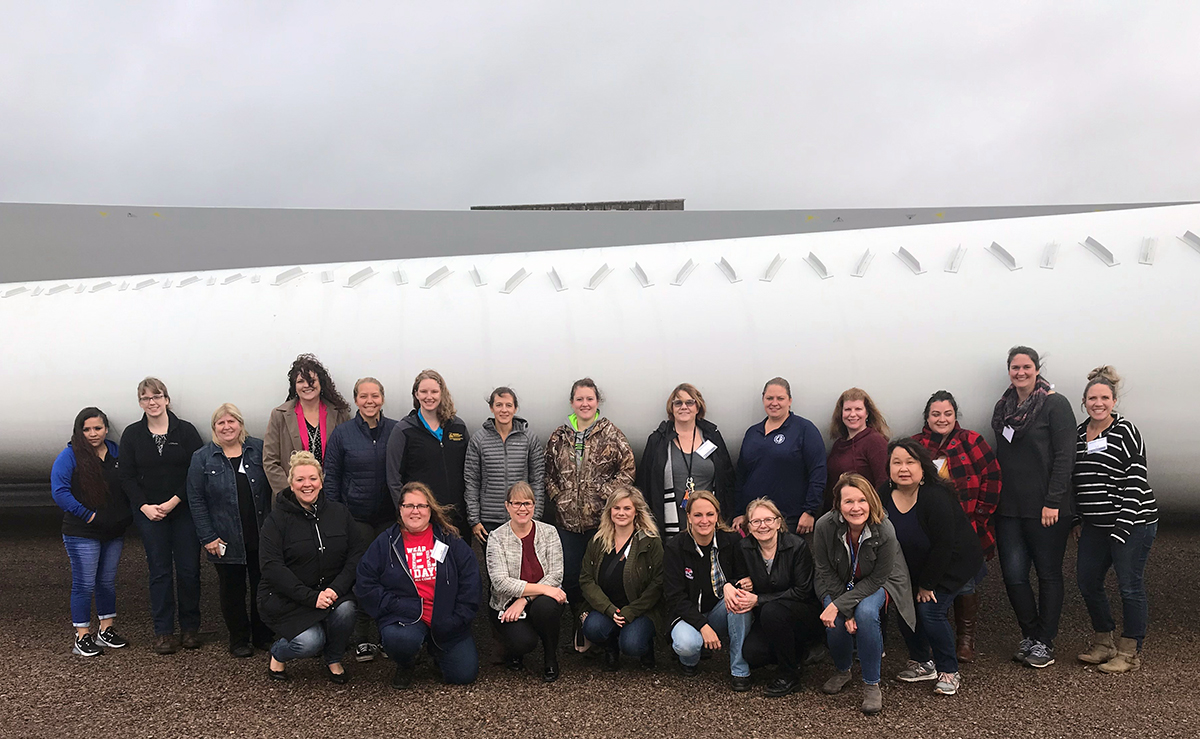 Group photo in front of a wind turbine blade